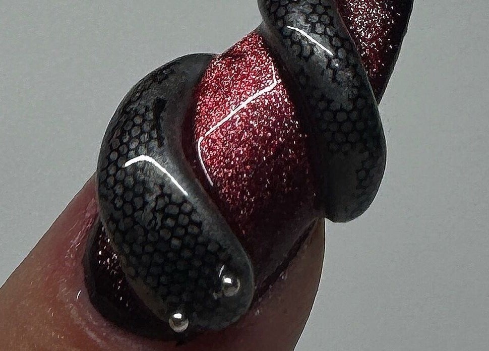 Intricate snake-themed nail art by Byhollie in Rochdale, England, GB, featuring black and red design.