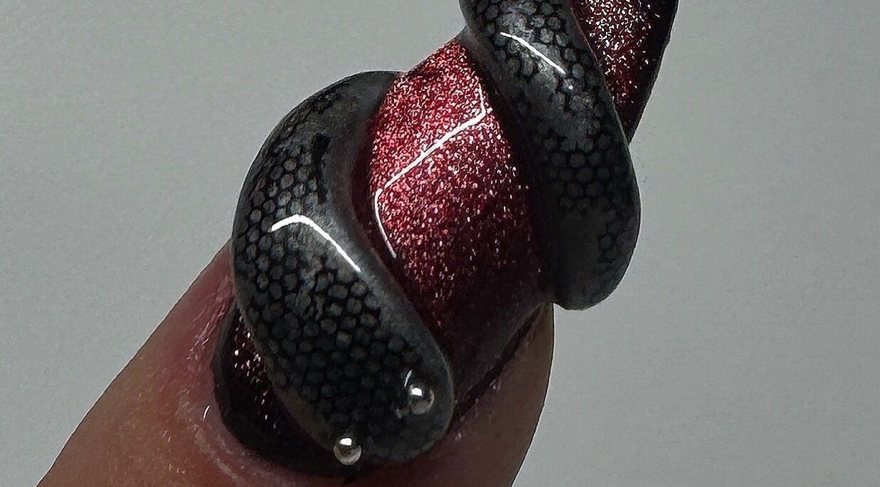 Intricate snake-themed nail art by Byhollie in Rochdale, England, GB, featuring black and red design.