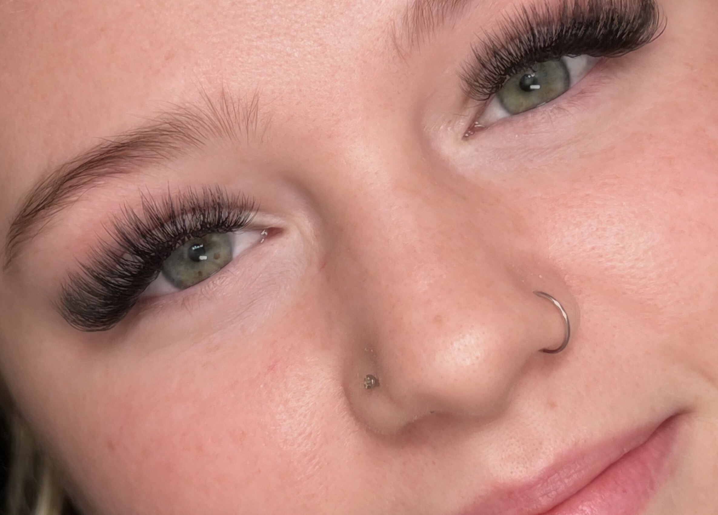 Stunning lash extensions by Mimi Does Lashes in Dartmouth, Nova Scotia, CA on a smiling client.