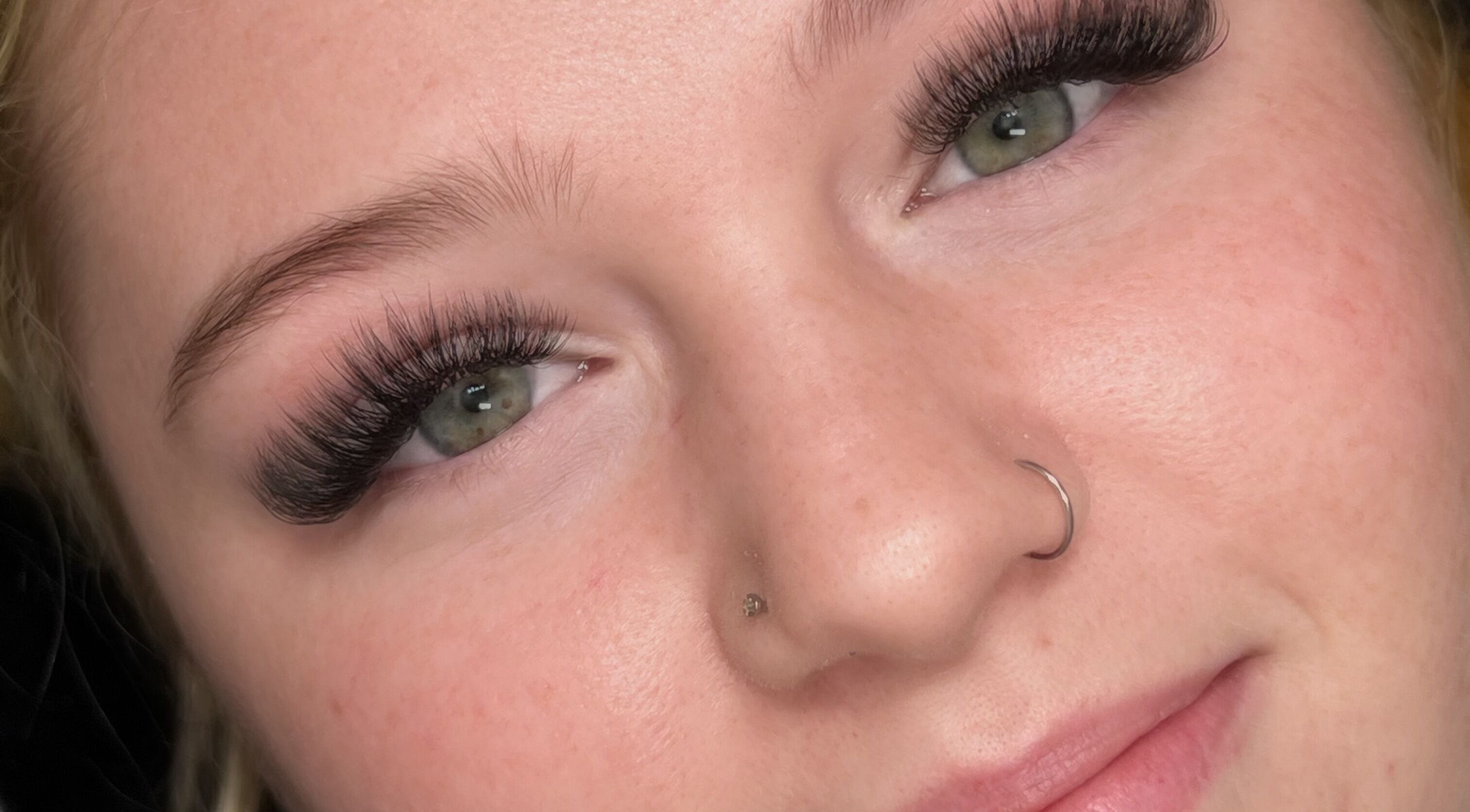 Stunning lash extensions by Mimi Does Lashes in Dartmouth, Nova Scotia, CA on a smiling client.