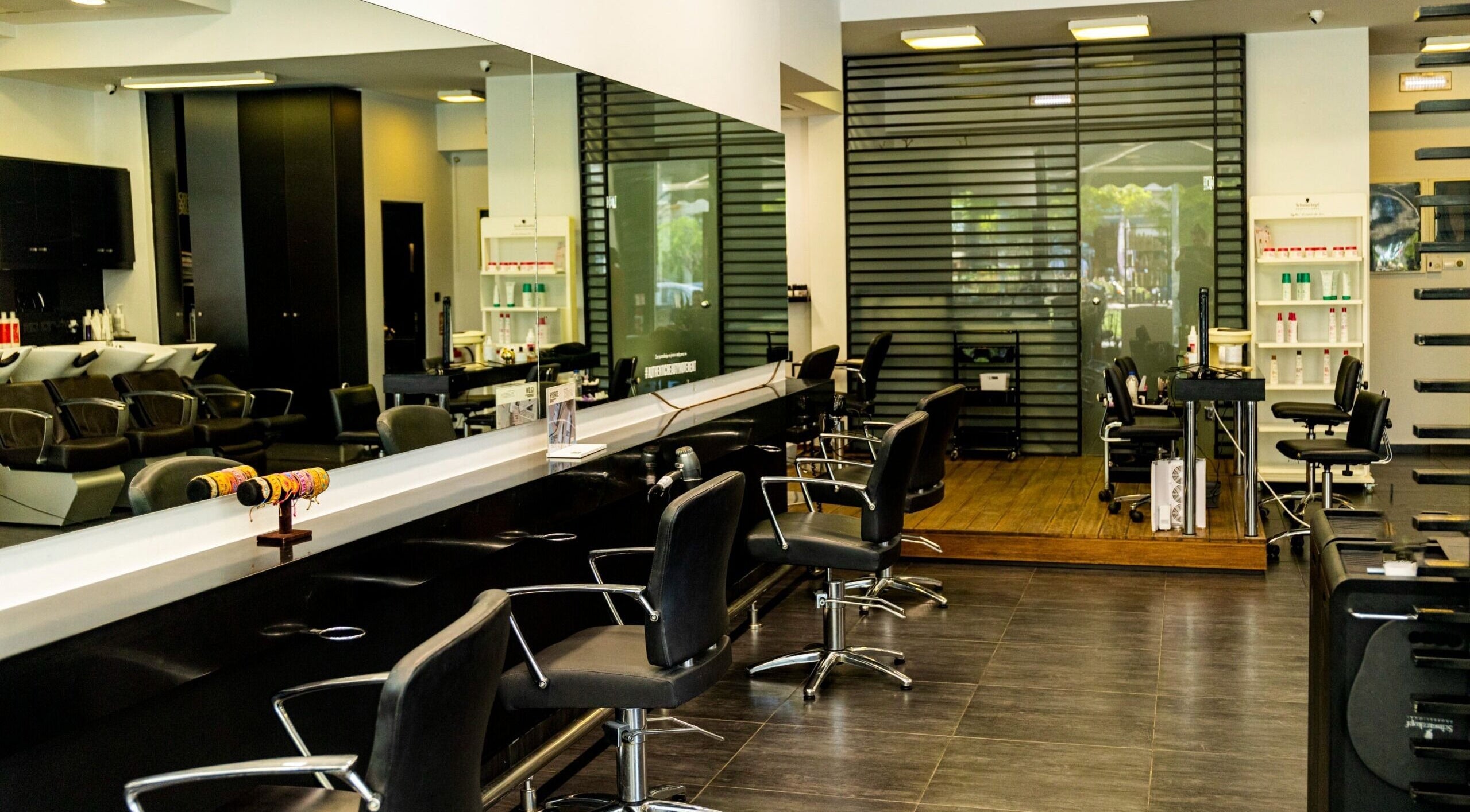 Εσωτερικός χώρος του Face to Face, κομμωτήριο στην Νέα Σμύρνη GR με καρέκλες και καθρέφτες.