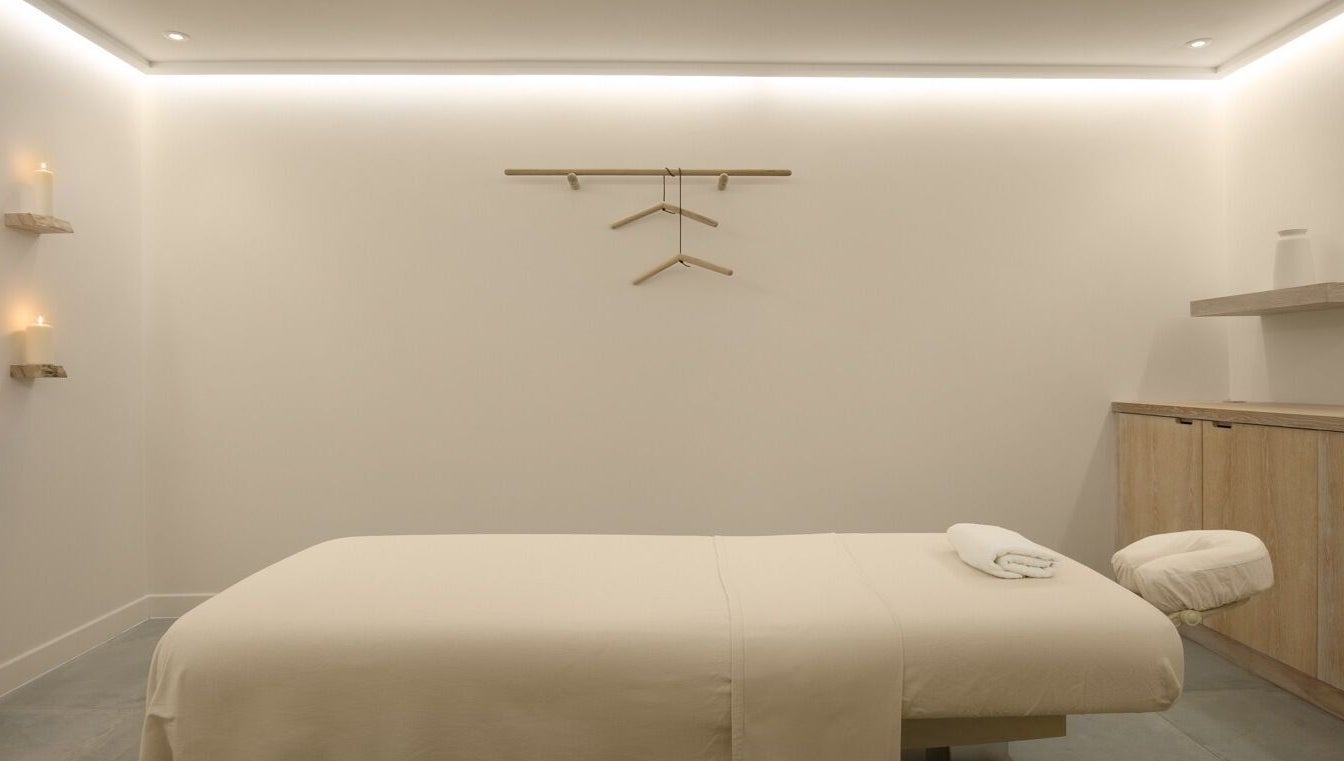 Serene massage room at The Method, Edinburgh, Scotland, GB, with a neatly arranged massage table and soft lighting.