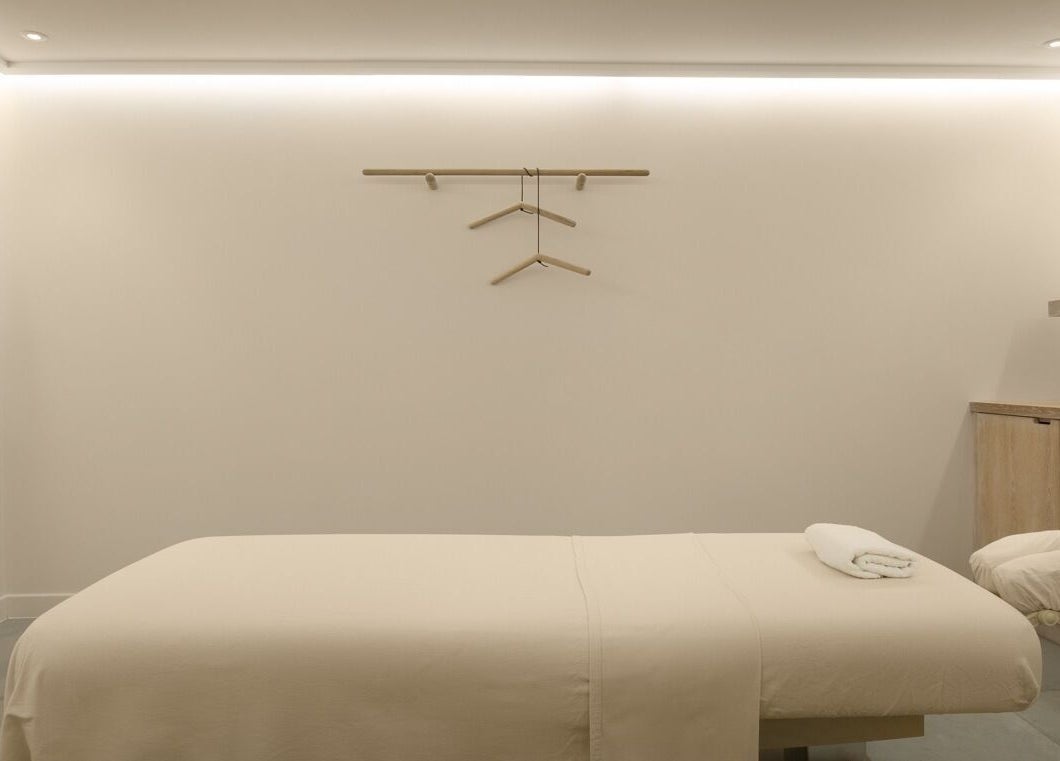 Serene massage room at The Method, Edinburgh, Scotland, GB, with a neatly arranged massage table and soft lighting.