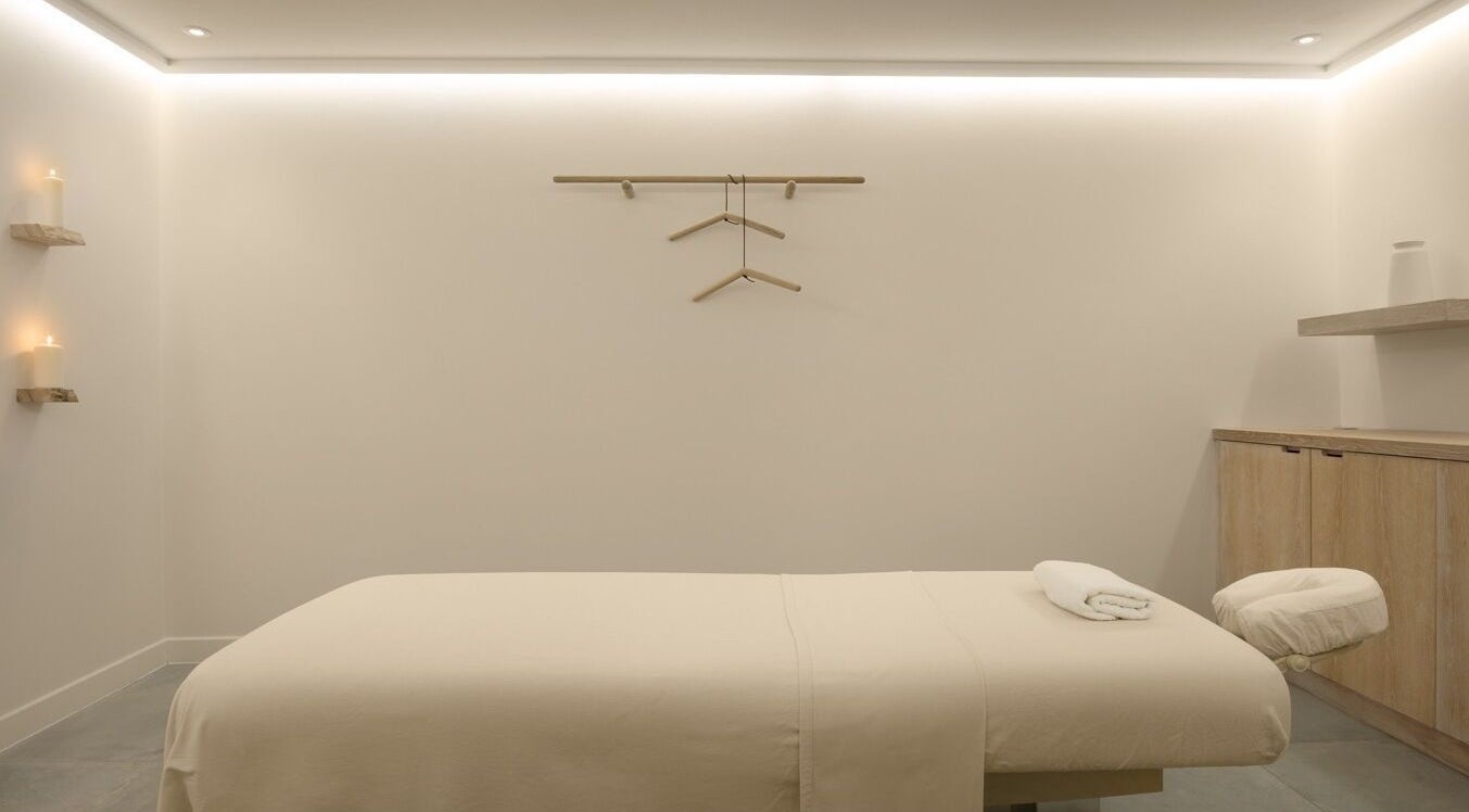 Serene massage room at The Method, Edinburgh, Scotland, GB, with a neatly arranged massage table and soft lighting.