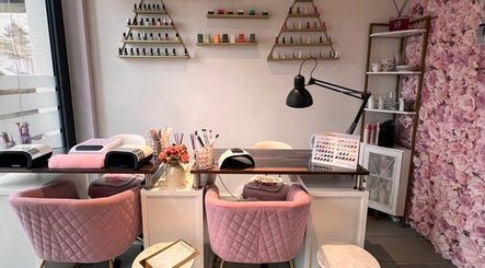 Espace manucure élégant chez G Beauty Geneve à Vernier, Genève, CH, avec chaises roses et murs fleuris.