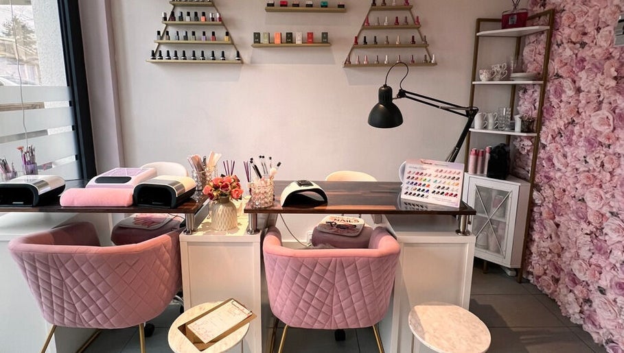 Espace manucure chic à G Beauty Geneve, Vernier, Genève, CH, avec sièges roses et mur de fleurs.
