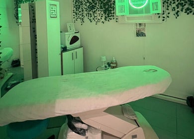 Salle de soins apaisante chez G Beauty Geneve à Vernier, Genève, CH, décorée de plantes et lumière verte.