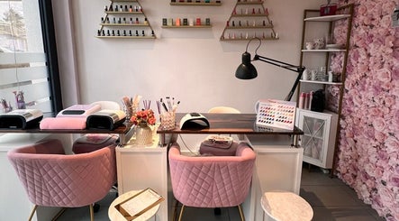 Intérieur chic de G Beauty Geneve à Vernier, Genève, CH, avec fauteuils roses et présentoirs de vernis.