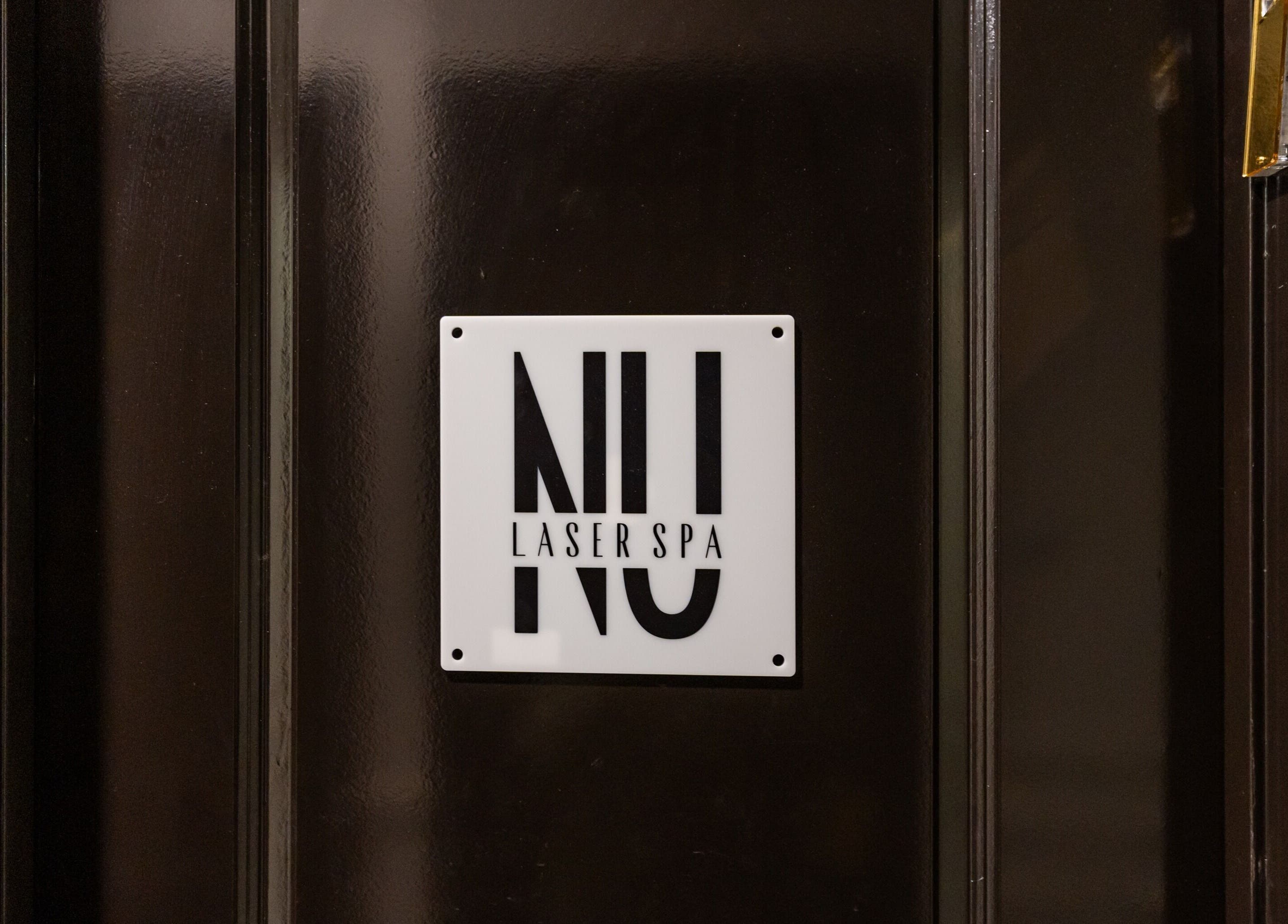 Entrance sign of NU Laser Spa in Great Neck Plaza, New York, US, highlighting its elegant logo.
