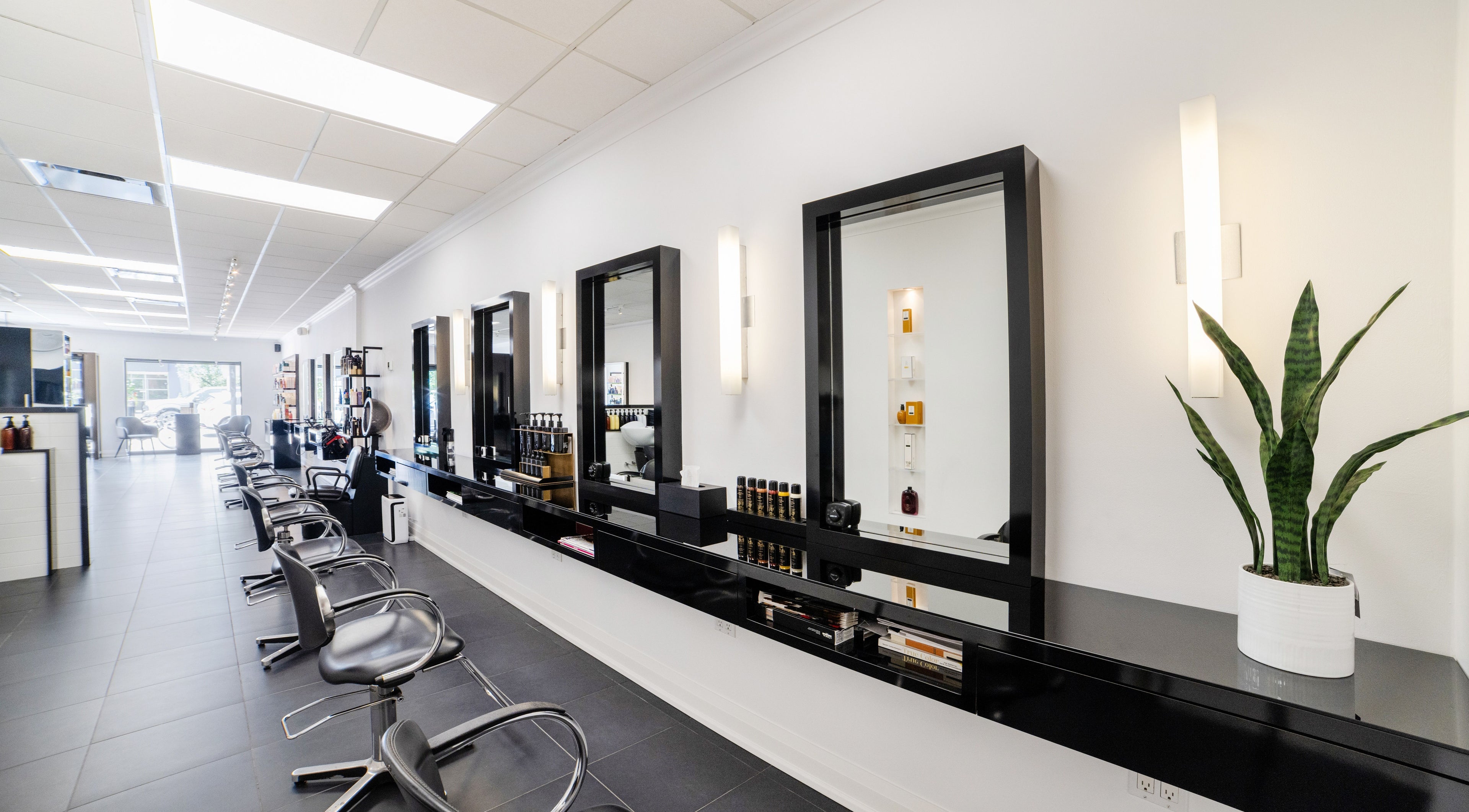Modern interior of MARCOSTEFANO SALON in Oakville, Ontario, CA with stylish black chairs and mirrors.