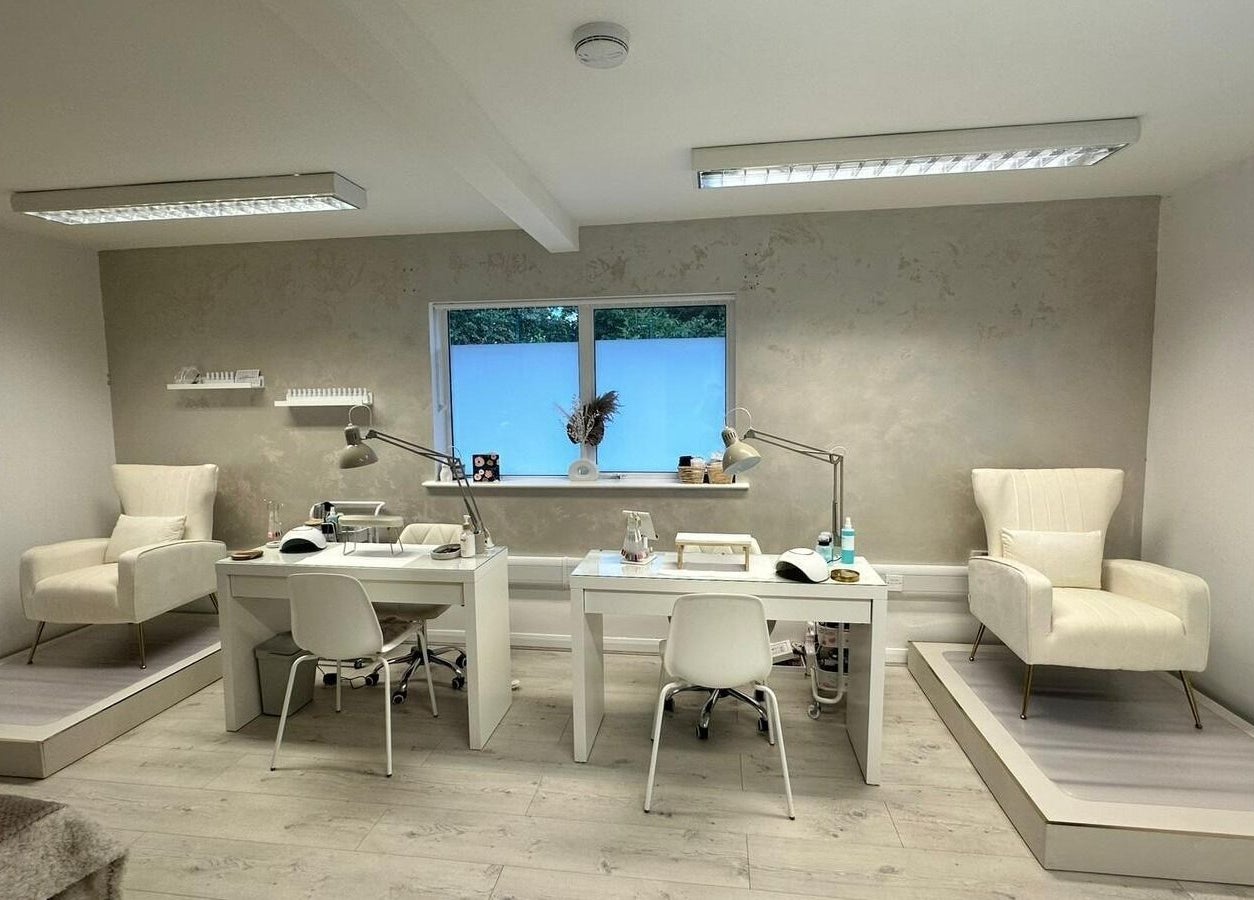 Modern interior of JM Aesthetically Yours in Hilton, England, GB with stylish chairs and manicure stations.