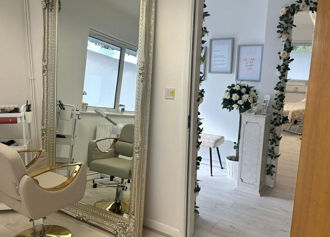 Stylish beauty chair and ornate mirror at JM Aesthetically Yours, Hilton, England, GB, creating a serene ambiance.
