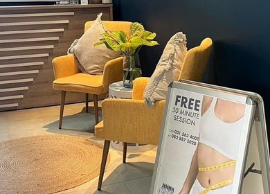 Inviting seating area at The Firm Durban North, Durban North, Kwazulu-natal, ZA with yellow chairs and a promo sign.