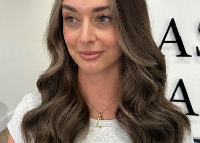 Smiling woman with styled wavy hair at Luke East Hair in Birmingham, England, GB.