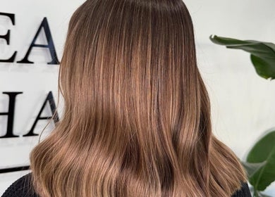 A stylish brunette hairstyle at Luke East Hair in Birmingham, England, GB, showcasing glossy locks.