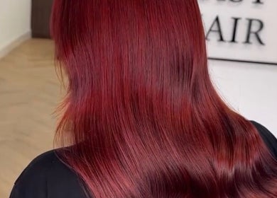 Vibrant red hair styled at Luke East Hair, Birmingham, England, GB. Showcasing expert hair coloring and styling.