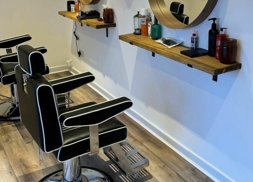 Modern barber chairs at Headspace Barbers, Walsall, England, GB. Sleek design with wooden shelves.