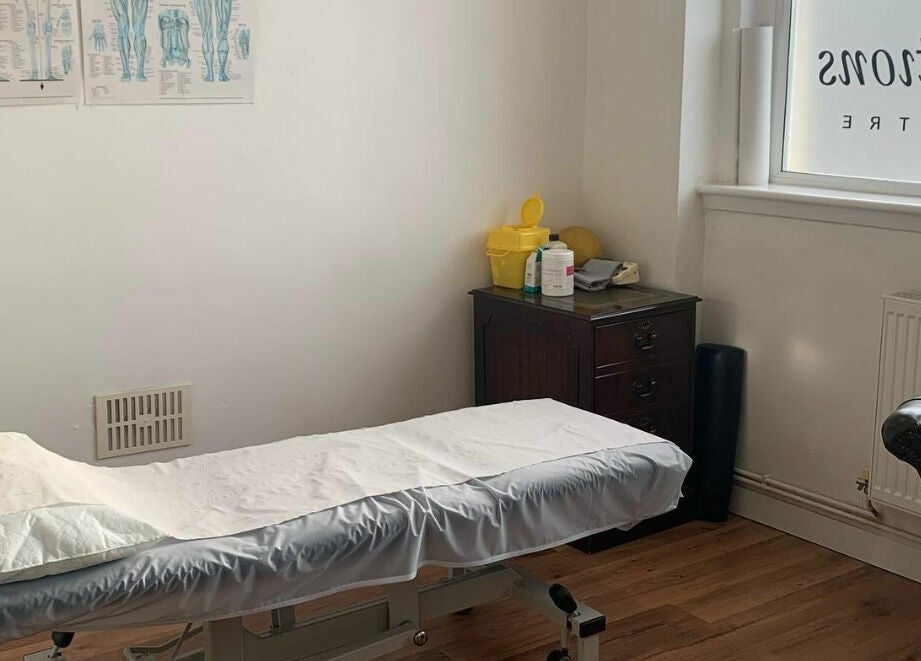 A tranquil treatment room at Swansea Health Solutions, Gowerton, Wales, GB, featuring a massage table.