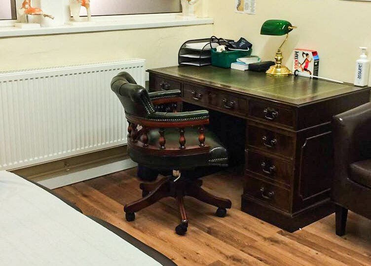 Elegant office space at Swansea Health Solutions, Gowerton, Wales, GB featuring a vintage desk and leather chair.