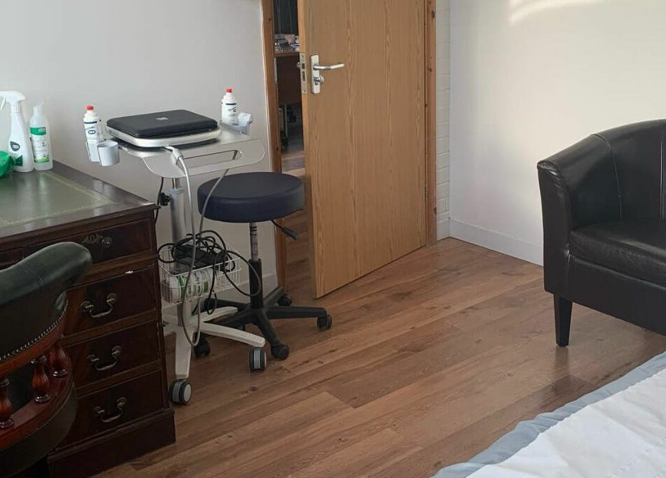 Inviting treatment room at Swansea Health Solutions, Gowerton, Wales, GB, featuring warm decor and comfortable seating.