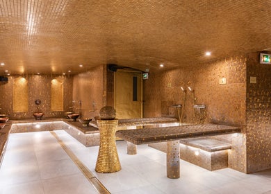 Salle dorée de Les Bains d'AliA, spa à Bagneux, Île-de-France, FR avec mosaïques et bassins.