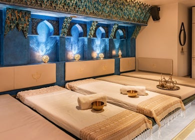 Salle de détente luxueuse aux Bains d'AliA à Bagneux, Île-de-France, FR avec lits et décor oriental.