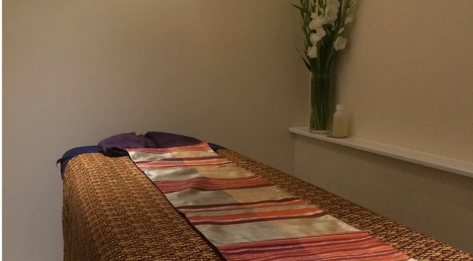 Relaxing massage room at Thai Silk Massage, London, England, GB with a cozy bed and calming decor.