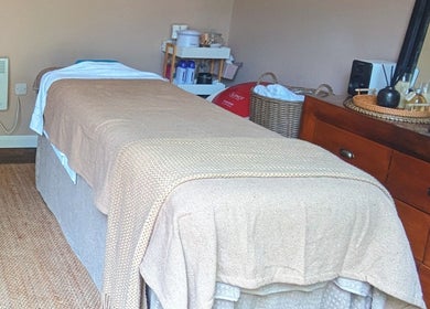 Relaxing treatment room at Sakura Wellness Institute, Audley, England, GB, featuring a comfortable massage table.