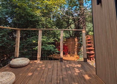 Relax on the serene wooden terrace of Sakura Wellness Institute in Audley, England, surrounded by lush greenery.