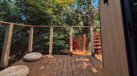 Relax on the serene wooden terrace of Sakura Wellness Institute in Audley, England, surrounded by lush greenery.