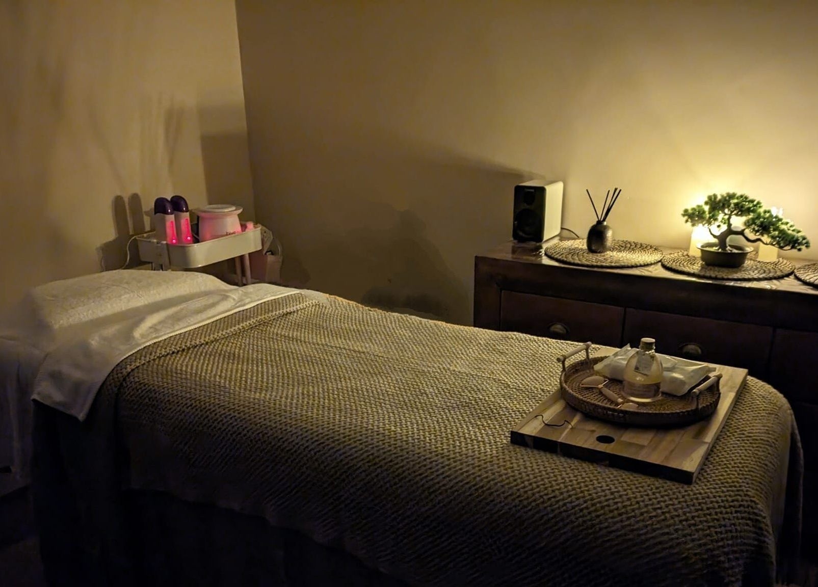 Serene massage room at Sakura Wellness Institute in Audley, England, GB with ambient lighting and calming decor.