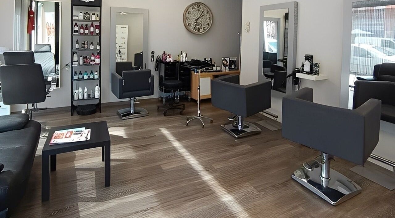 Interior de Esencia Hair Salon en Granollers, Catalunya, ES, mostrando sillones modernos y decoraciones elegantes.