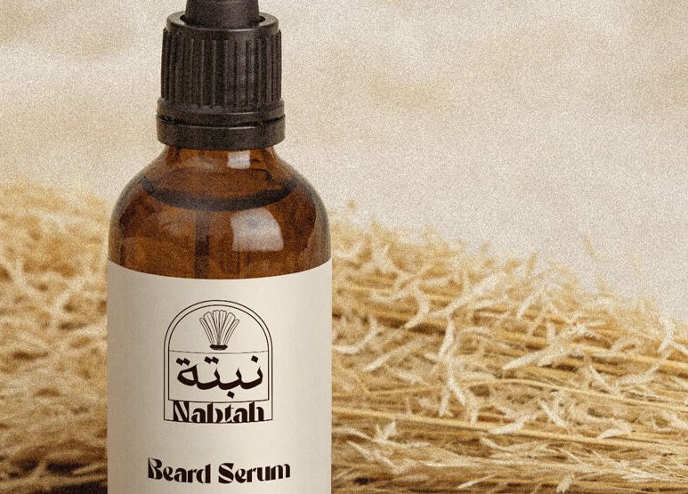 Beard serum bottle from Nabtah | صالون نبتة in Al Hofuf, Eastern Province, SA, set against straw background.