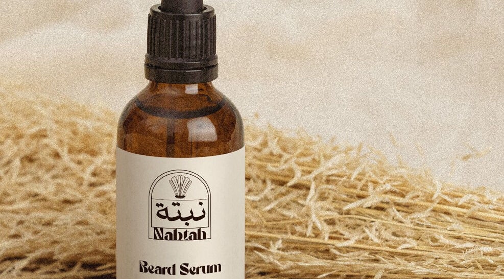 Beard serum bottle from Nabtah | صالون نبتة in Al Hofuf, Eastern Province, SA, set against straw background.