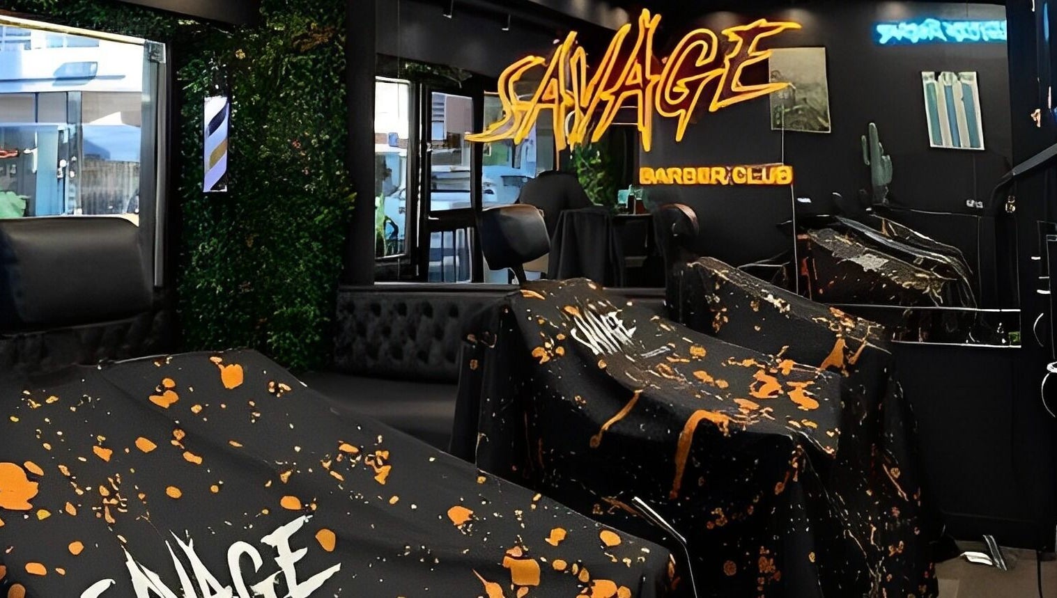 Interior de Savage Barber Club en Buenos Aires, con modernos sillones y neón decorativo.