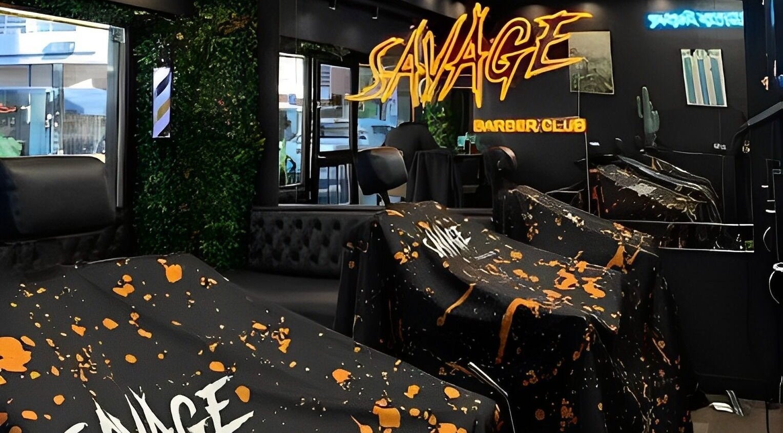 Interior de Savage Barber Club en Buenos Aires, con modernos sillones y neón decorativo.