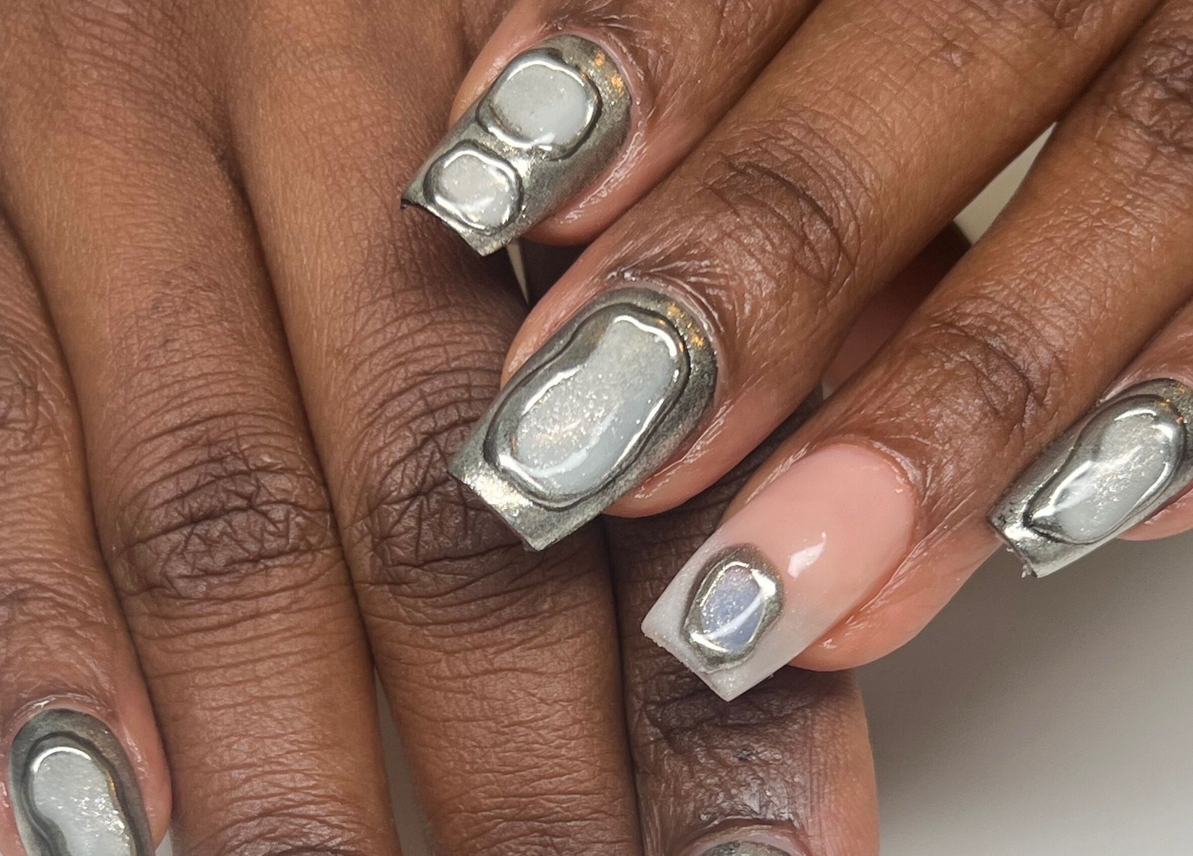 Unique chrome nail art at ÀTÍKÉ LONDON, showcasing trendy designs in London, England, GB.