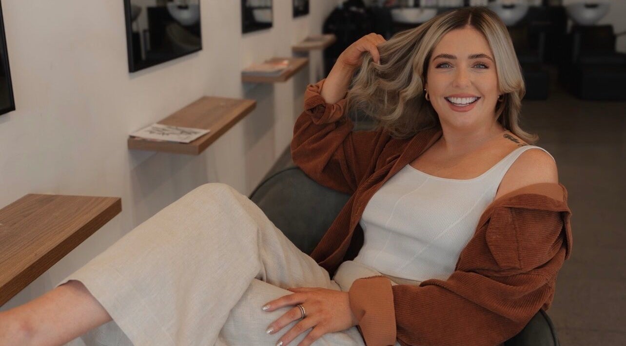 Smiling woman at Hair by Britt Louise, Singleton, New South Wales, AU, showcasing a chic, relaxed hairstyle.