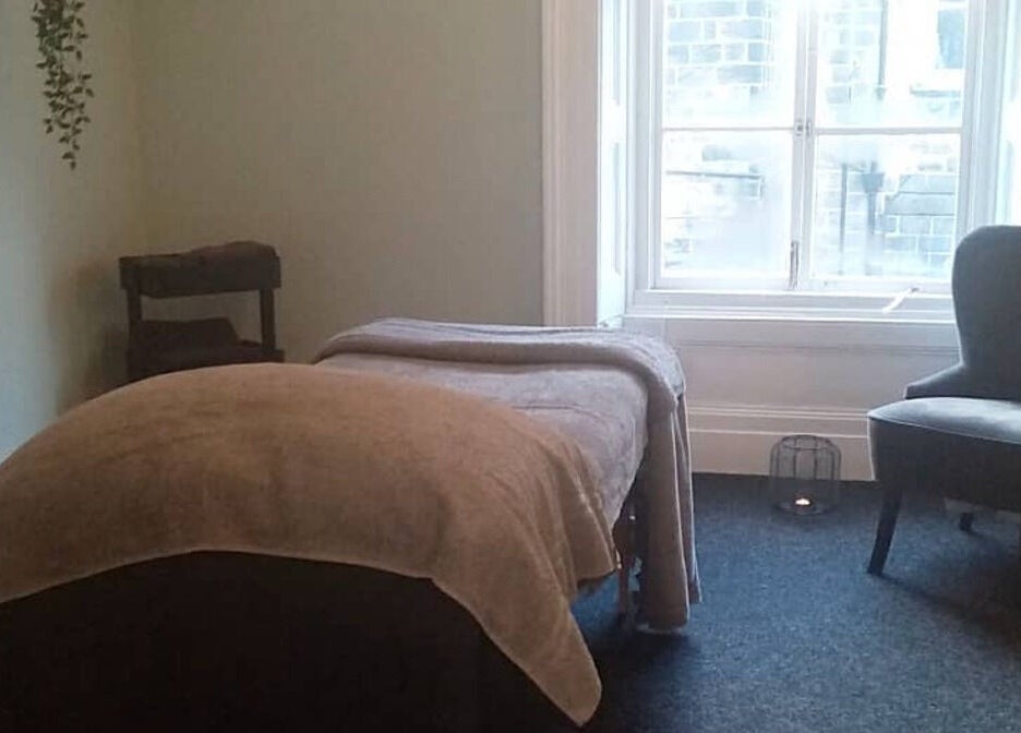 Tranquil massage room at Holistic BodyWork with Erica in Leeds, England, GB, featuring a cozy bed and chair.