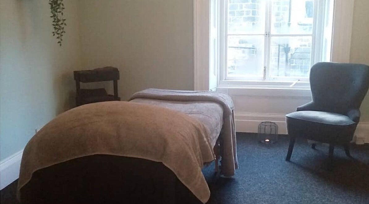 Tranquil massage room at Holistic BodyWork with Erica in Leeds, England, GB, featuring a cozy bed and chair.