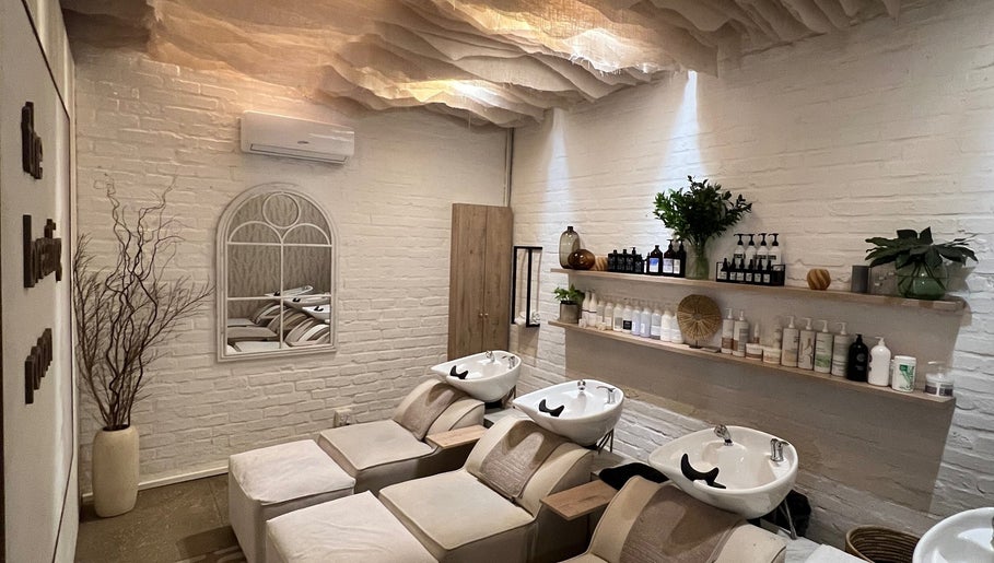 Relaxing wash area at BHAVA Hair Lounge, Gqeberha, Eastern Cape, ZA with cozy seating and stylish decor.