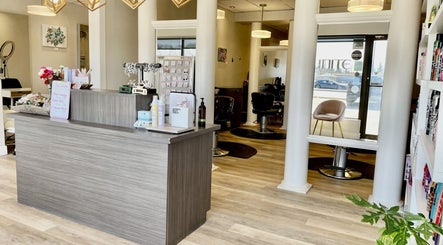 Reception area of Luxe Hair Studio in Regina, Saskatchewan, CA, featuring modern decor and styling chairs.