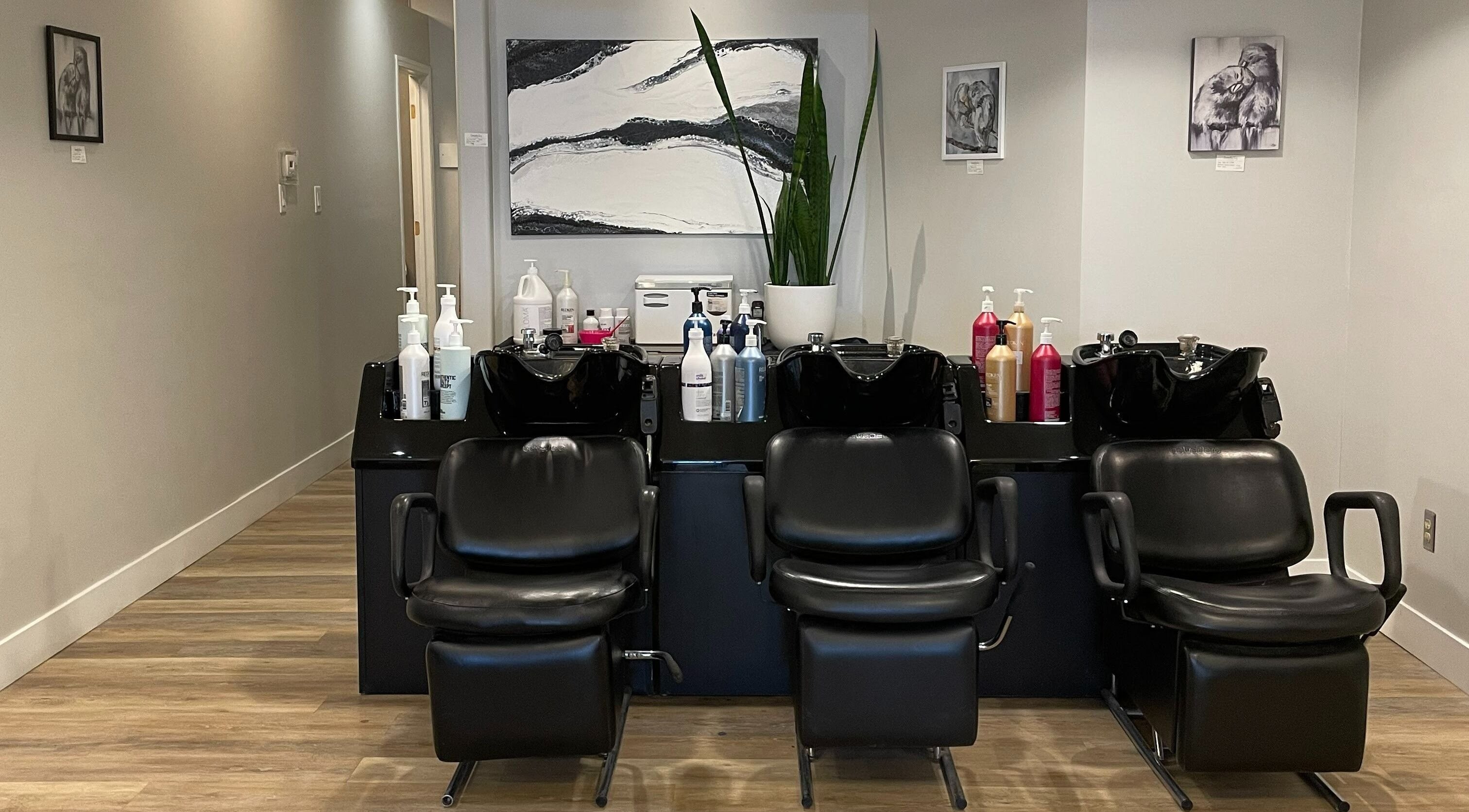 Elegant shampoo stations in Luxe Hair Studio at Regina, Saskatchewan, CA showcasing sleek black chairs.