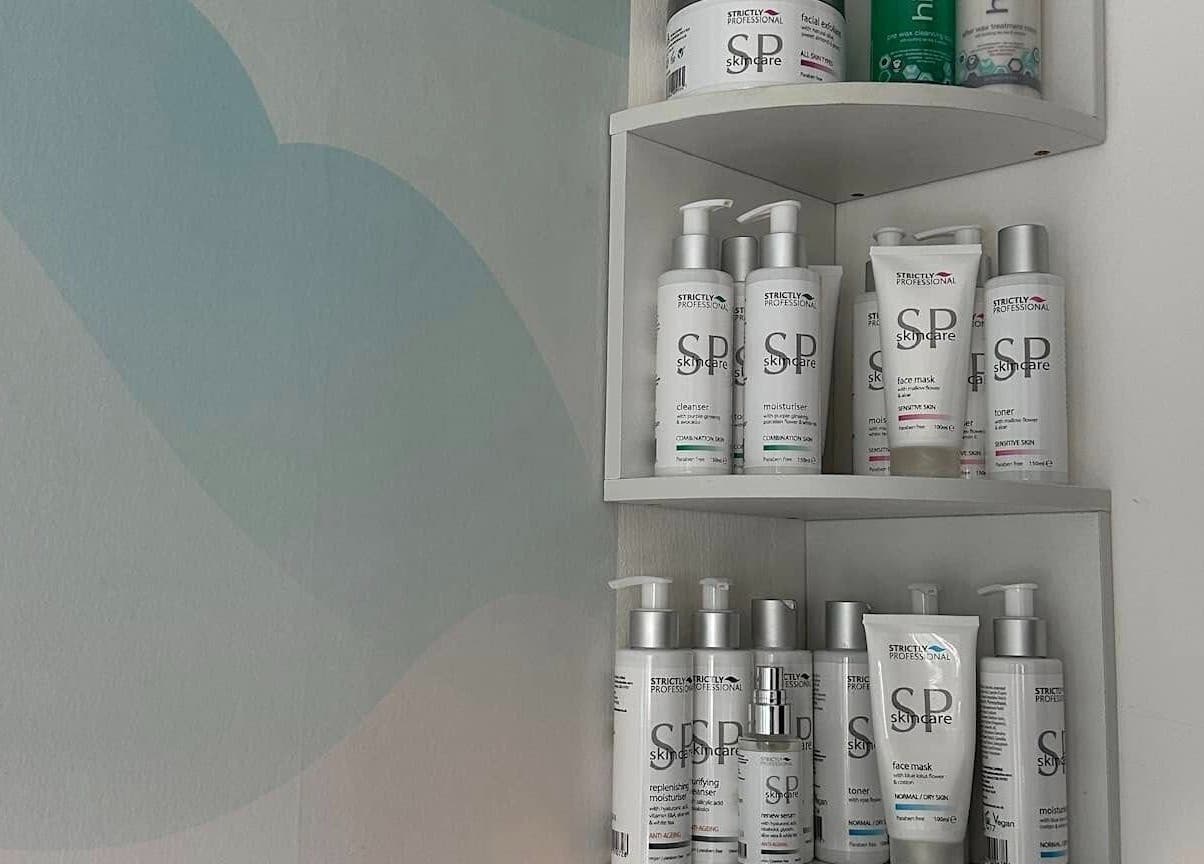 Shelf with skincare products at AR Beauty Bar, Stevenage, England, GB, featuring various lotions and cleansers.