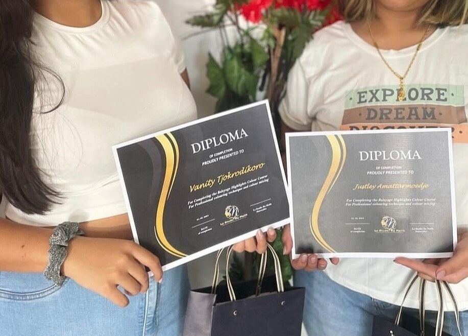 Graduates holding diplomas at Le Studio De Malik, Paramaribo, Paramaribo, SR. Celebrating achievements.