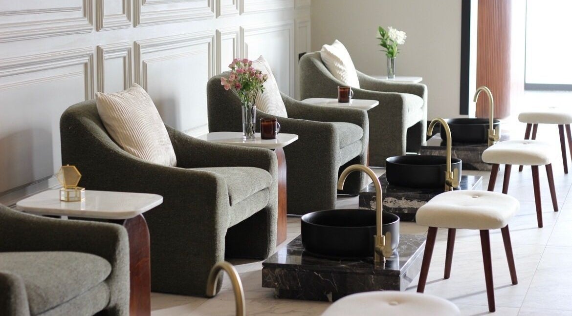 Elegant seating at Bee Spa | Nails & Hair in Riyadh, SA, with plush chairs and foot basins.
