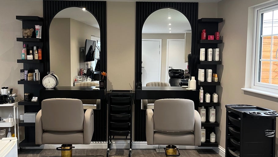 Stylish salon interior at Hair by Tia in Stanway, England, GB with modern chairs and products.