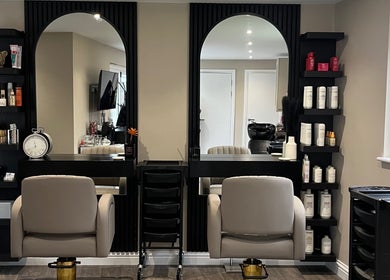 Stylish salon interior at Hair by Tia in Stanway, England, GB with modern chairs and products.