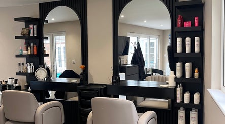 Elegant interior of 'Hair by Tia' salon in Stanway, England, GB, featuring modern decor and styling stations.