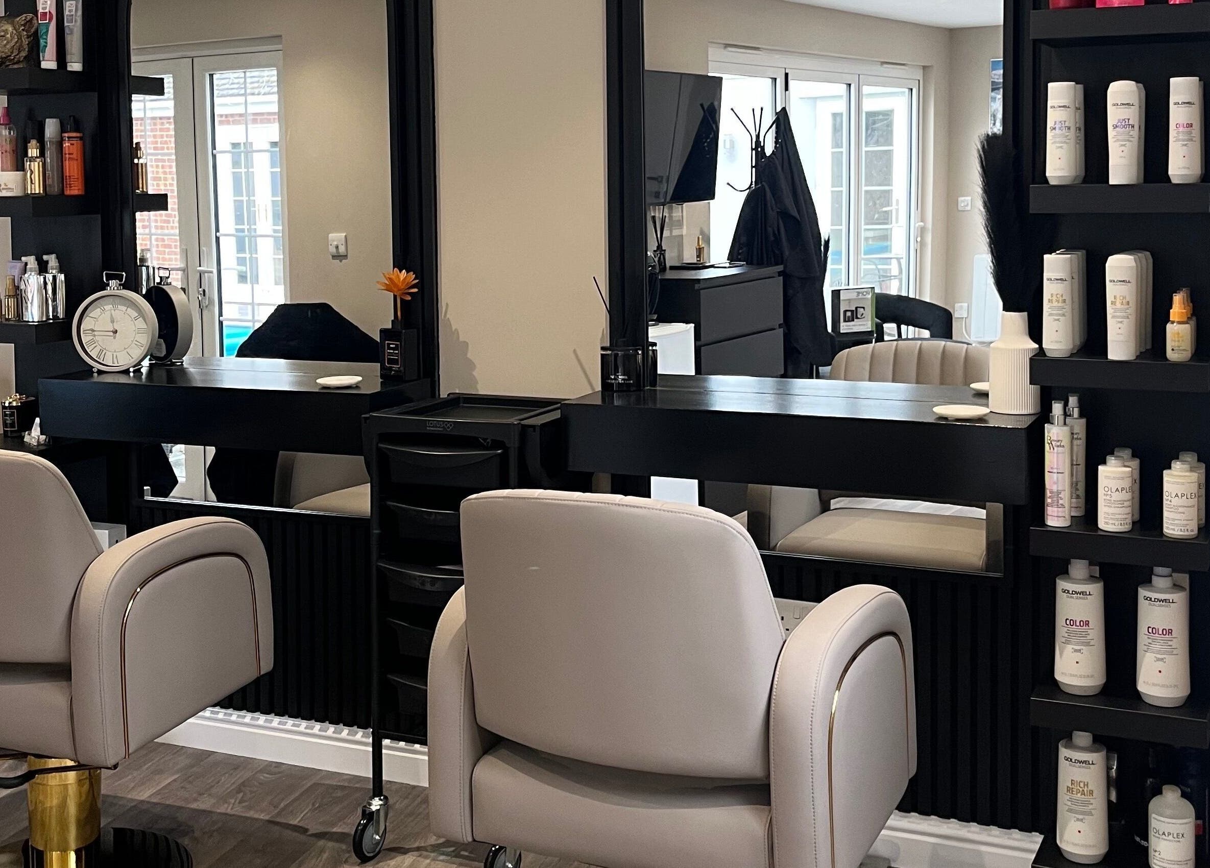 Chic salon setup at Hair by Tia in Stanway, England, GB with cozy chairs and shelves of premium hair products.